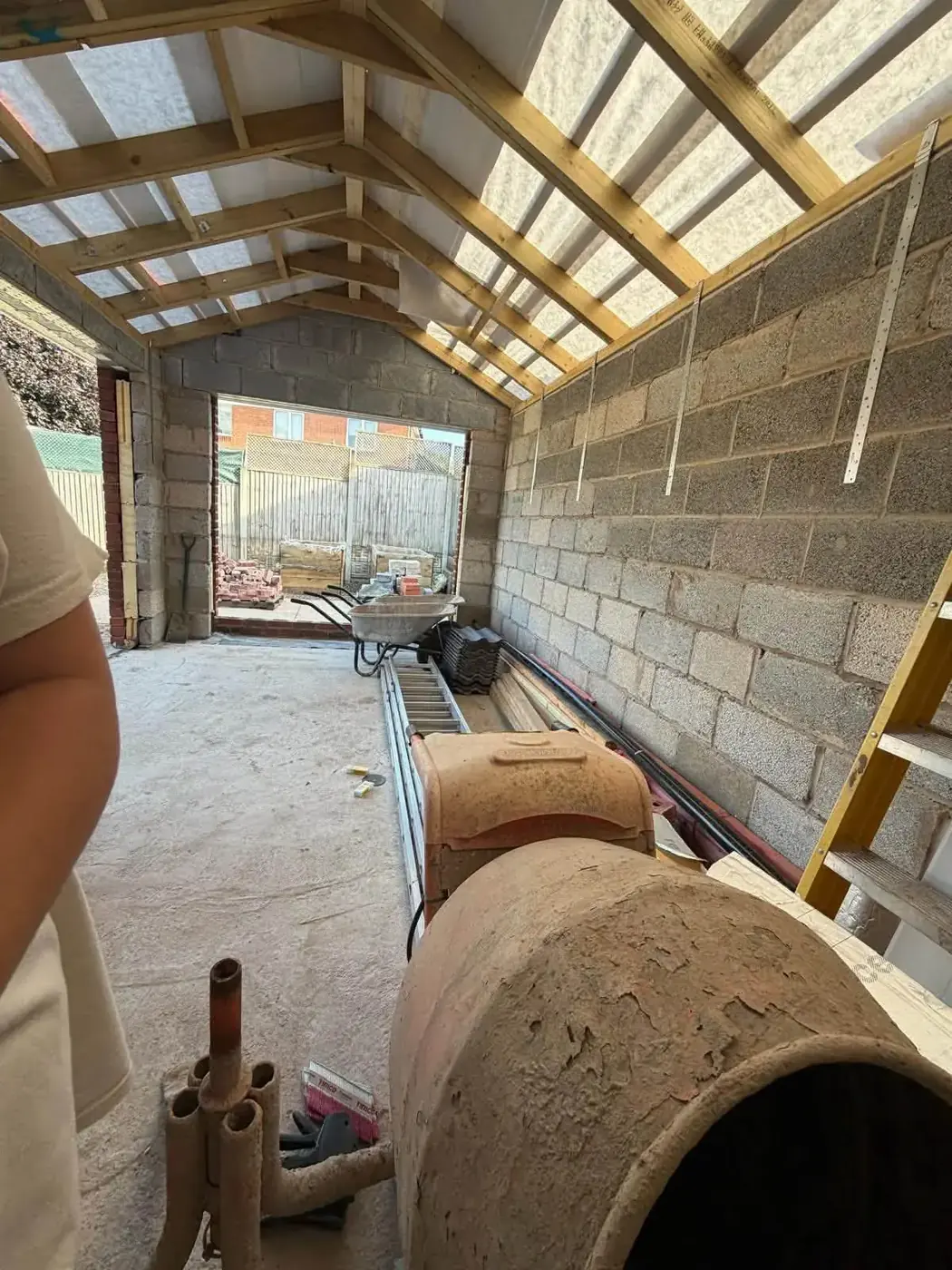 Home extension interior with blockwork walls and timber roof framing in progress