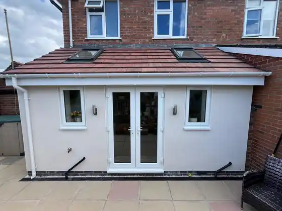 Completed rendered kitchen extension with windows and French doors