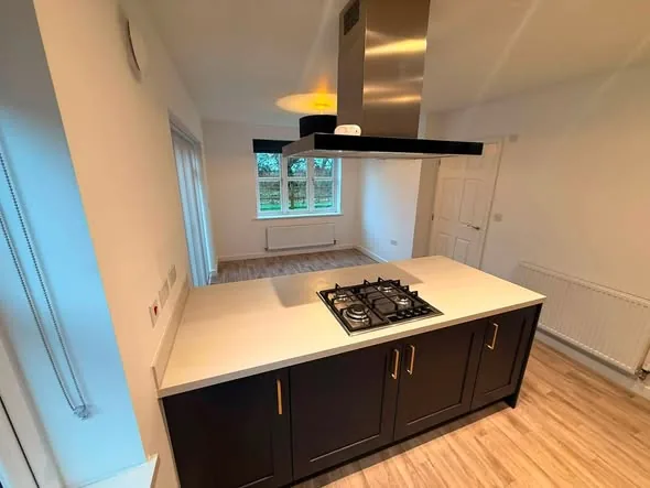 Kitchen island with hob and fitted cabinetry by Hardy and Sons