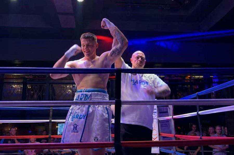 Team Hardy boxer celebrating in the ring with Hardy and Sons sponsorship on the fight shorts